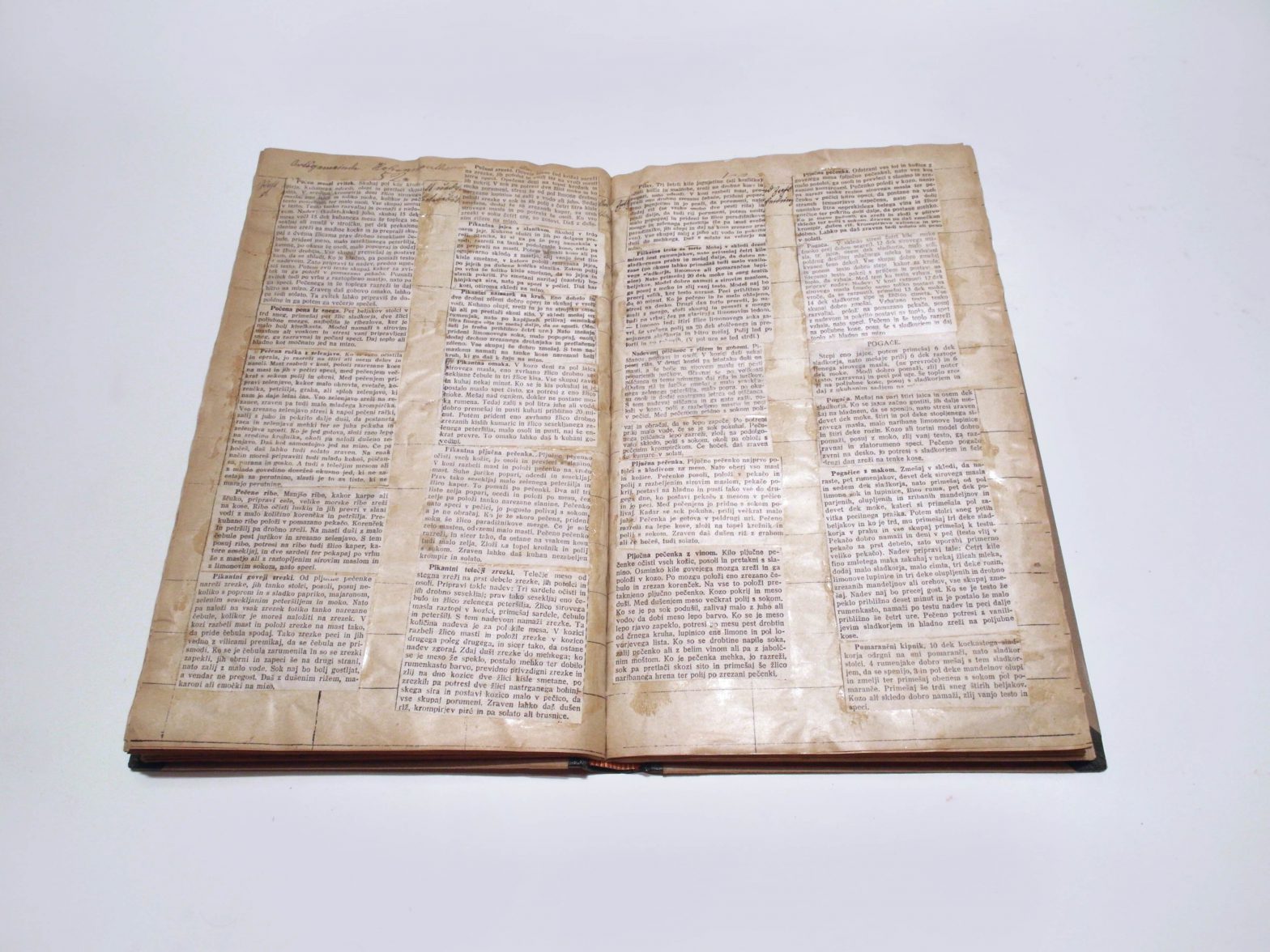 Pages show glued on newspaper texts.