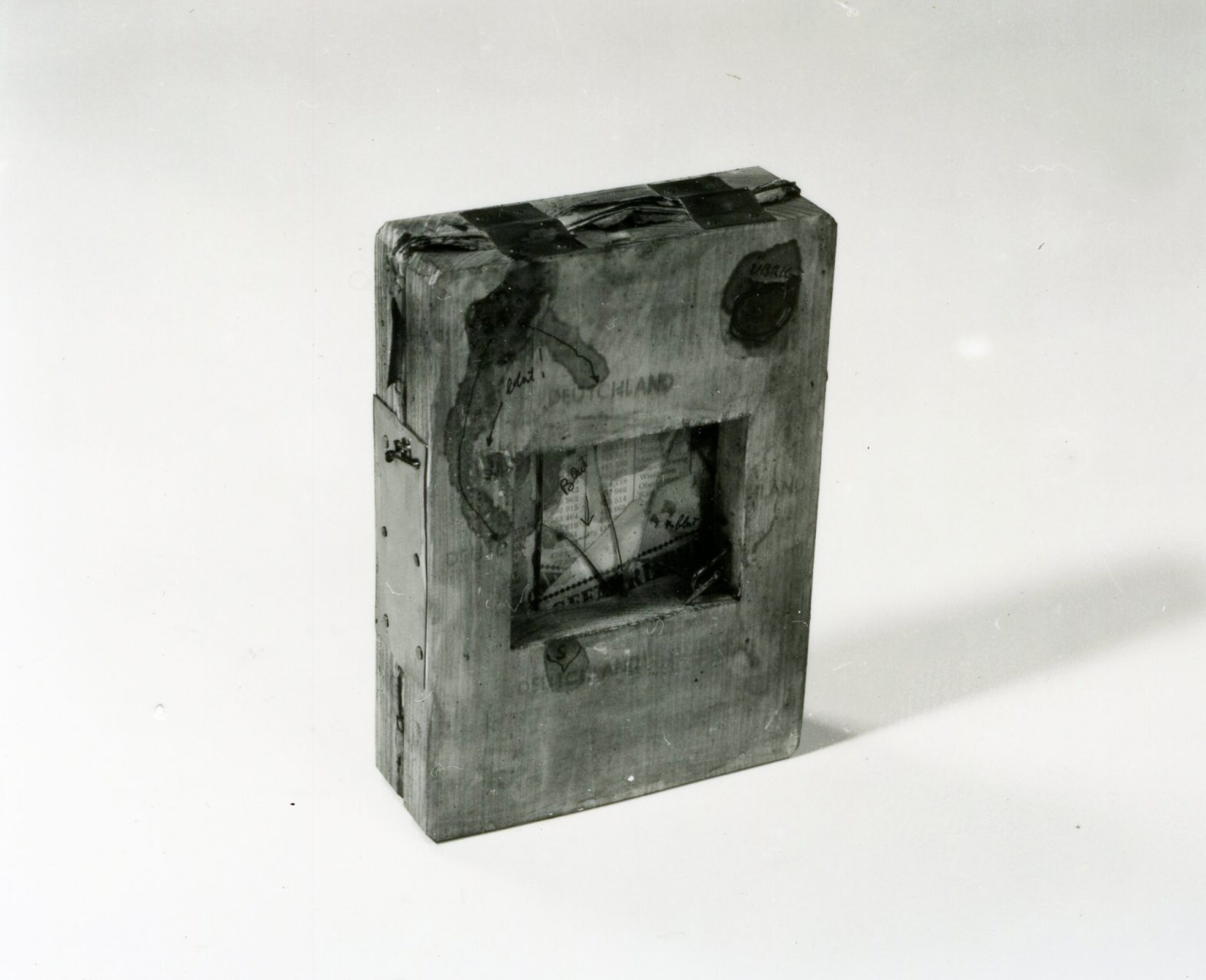 Old book squeezed inbetween 2 wooden panels nailed together.