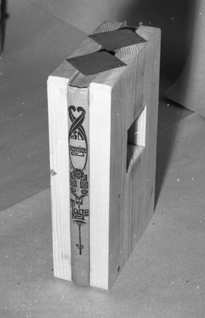 Book spine in between 2 wooden boards.